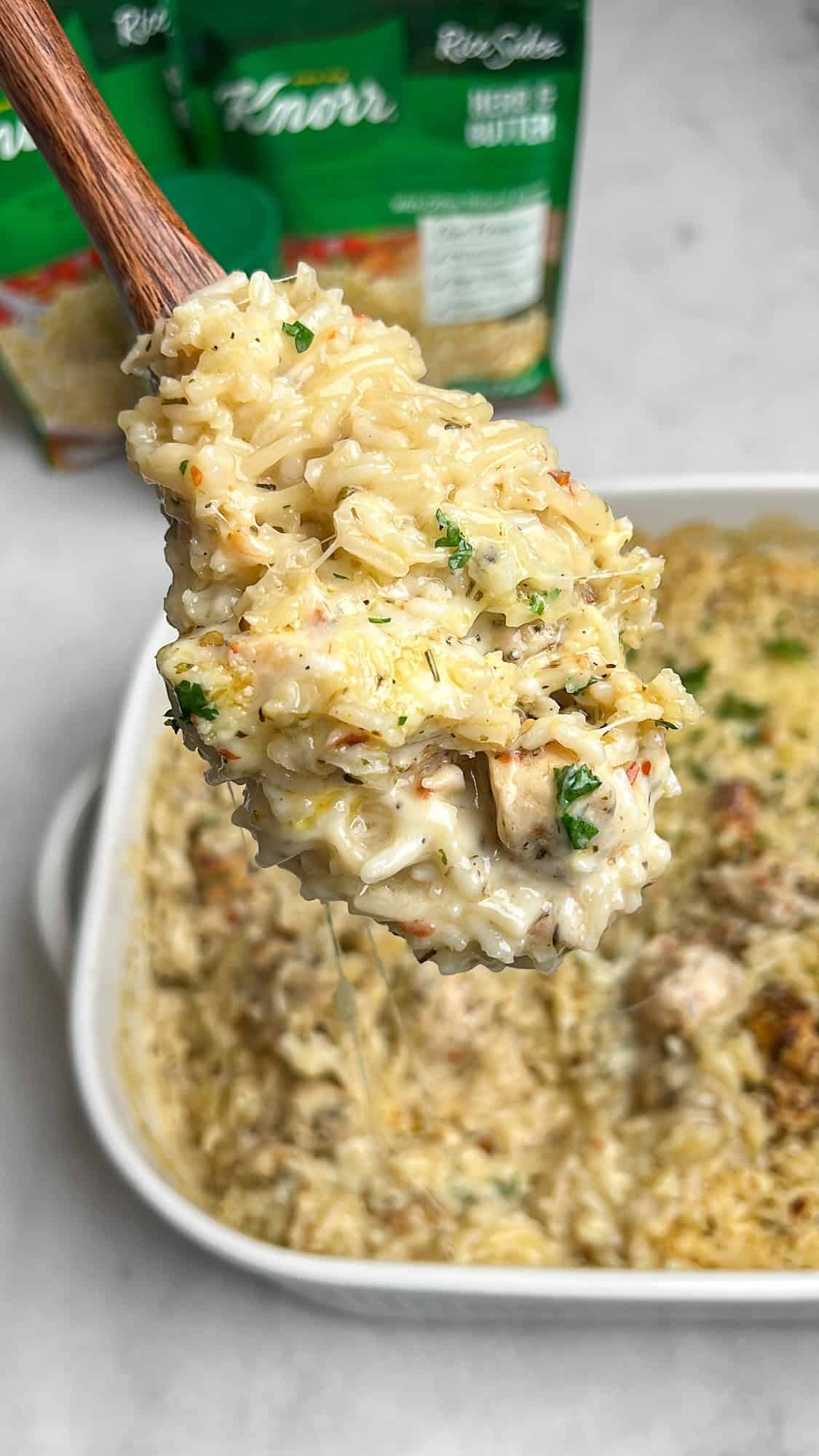 cheesy rice casserole with chicken on a large spoon