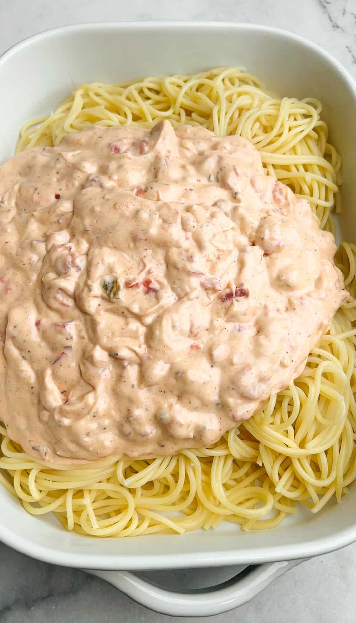 spaghetti and cream sauce in a casserole dish