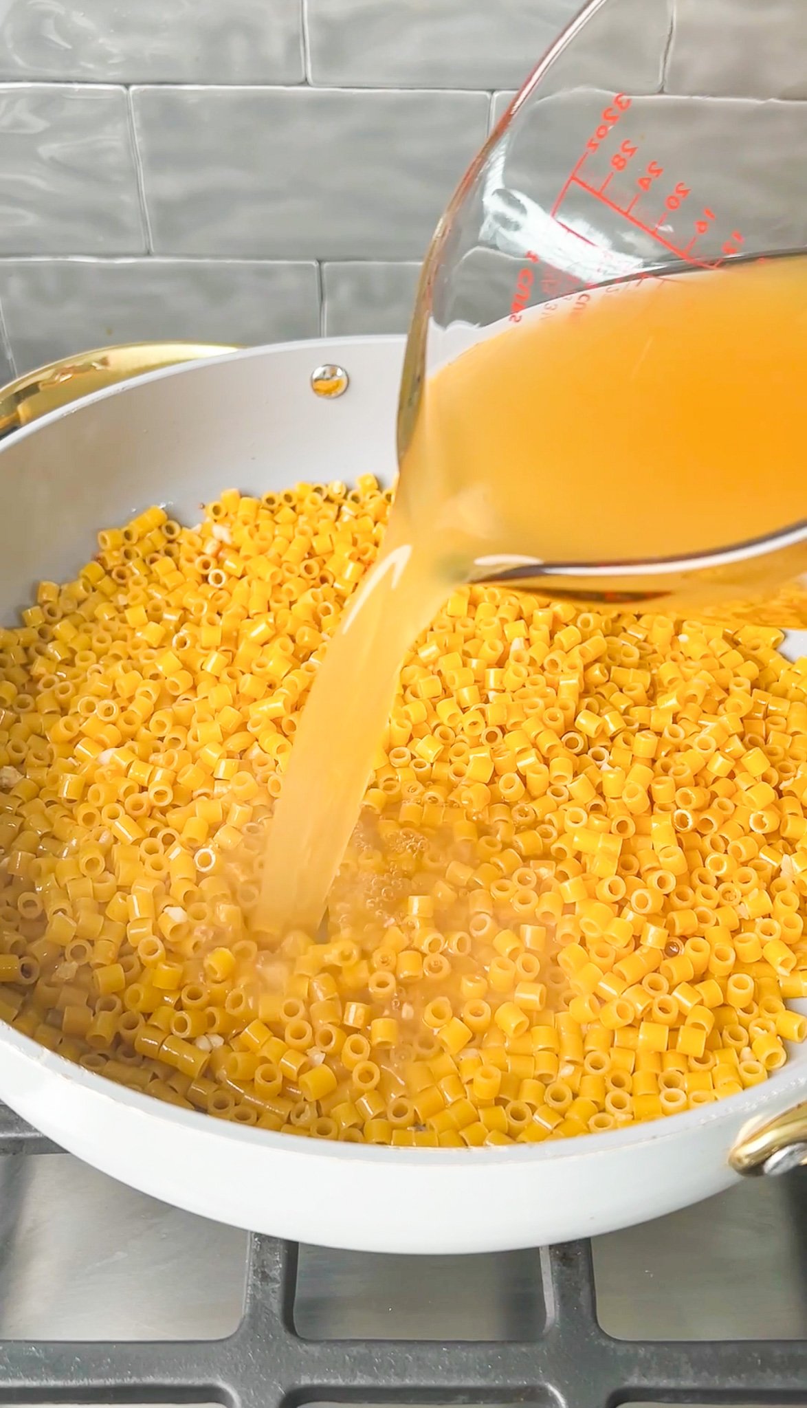 chicken broth being poured into a pan