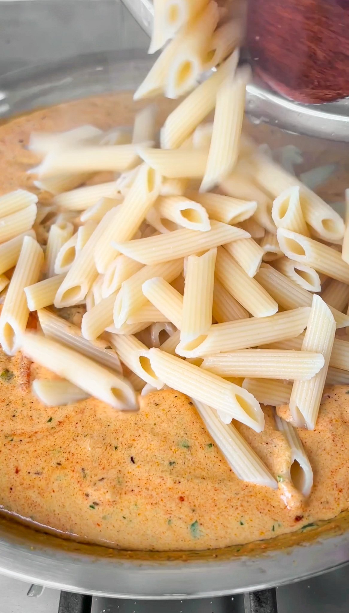 adding pasta into the cream sauce