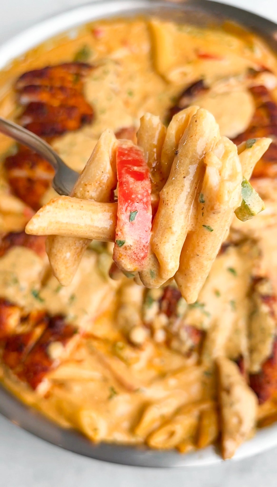 penne pasta with cajun cream sauce on a spoon