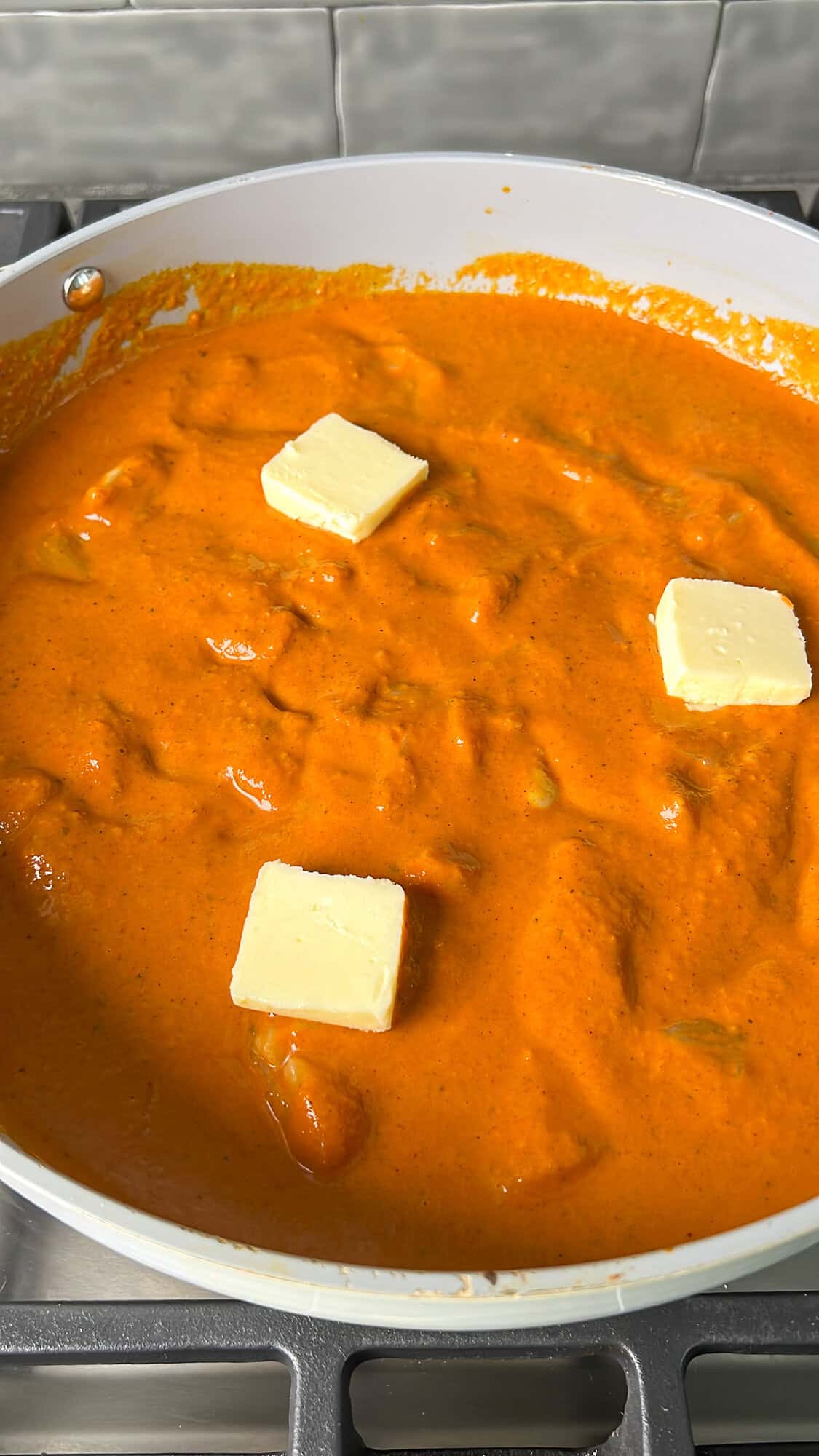 butter being added into the butter chicken