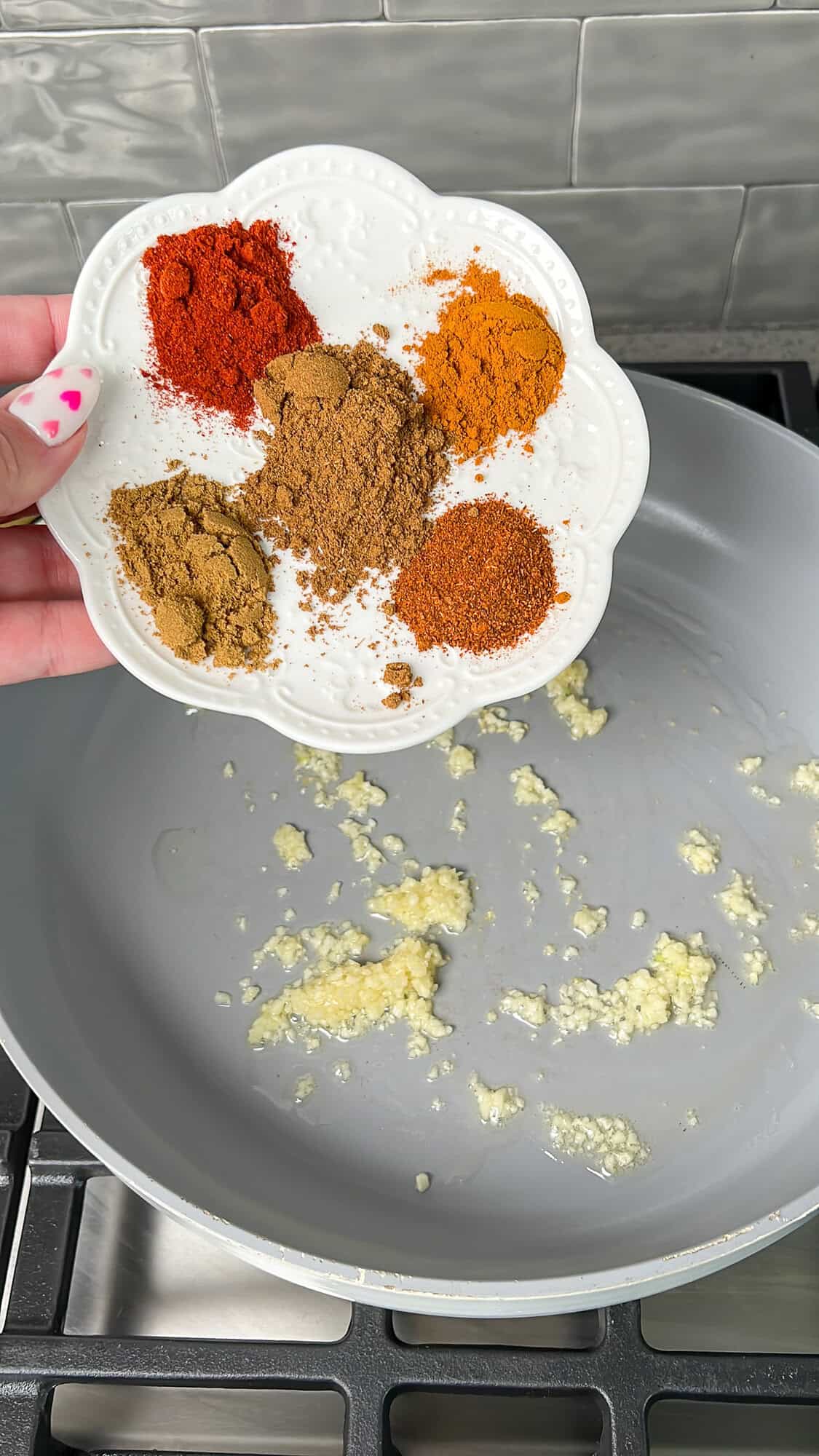 spices going into a skillet with garlic