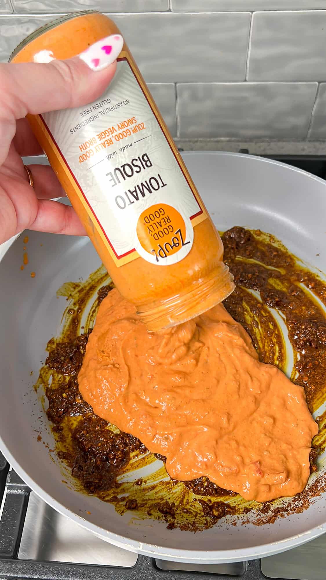 tomato base being added into pan