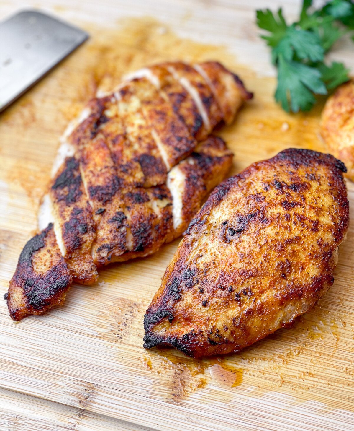 chicken breasts sitting sliced on a cutting board