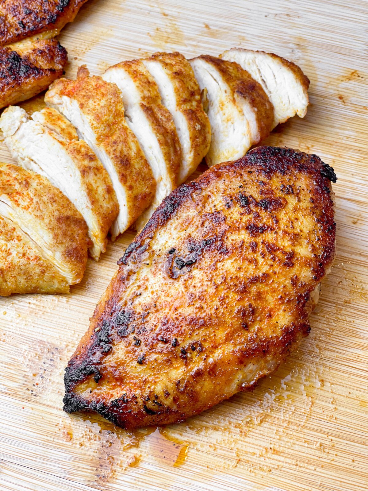 two chicken breasts sitting on a cutting board