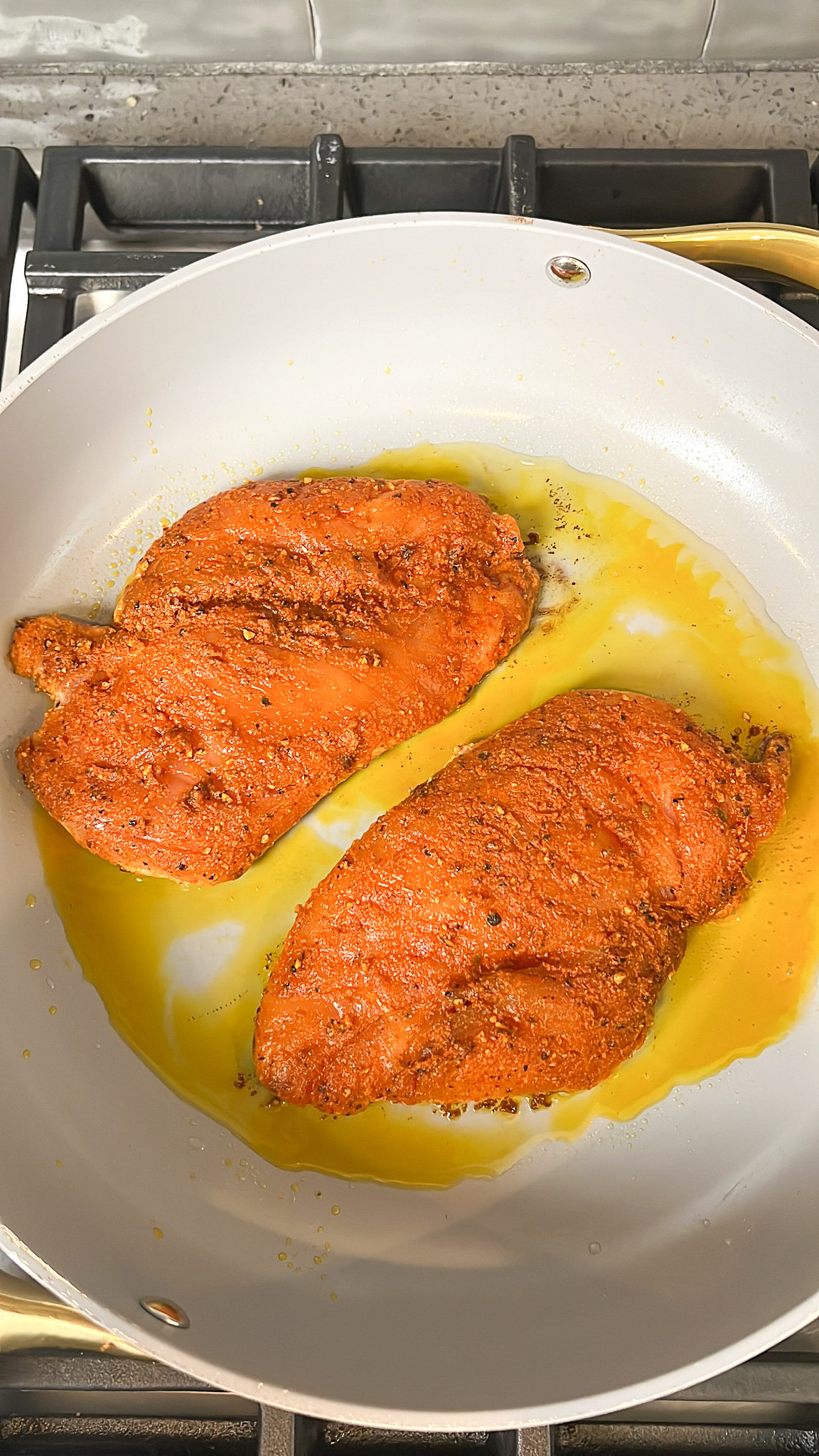 chicken breasts cooking in a pan