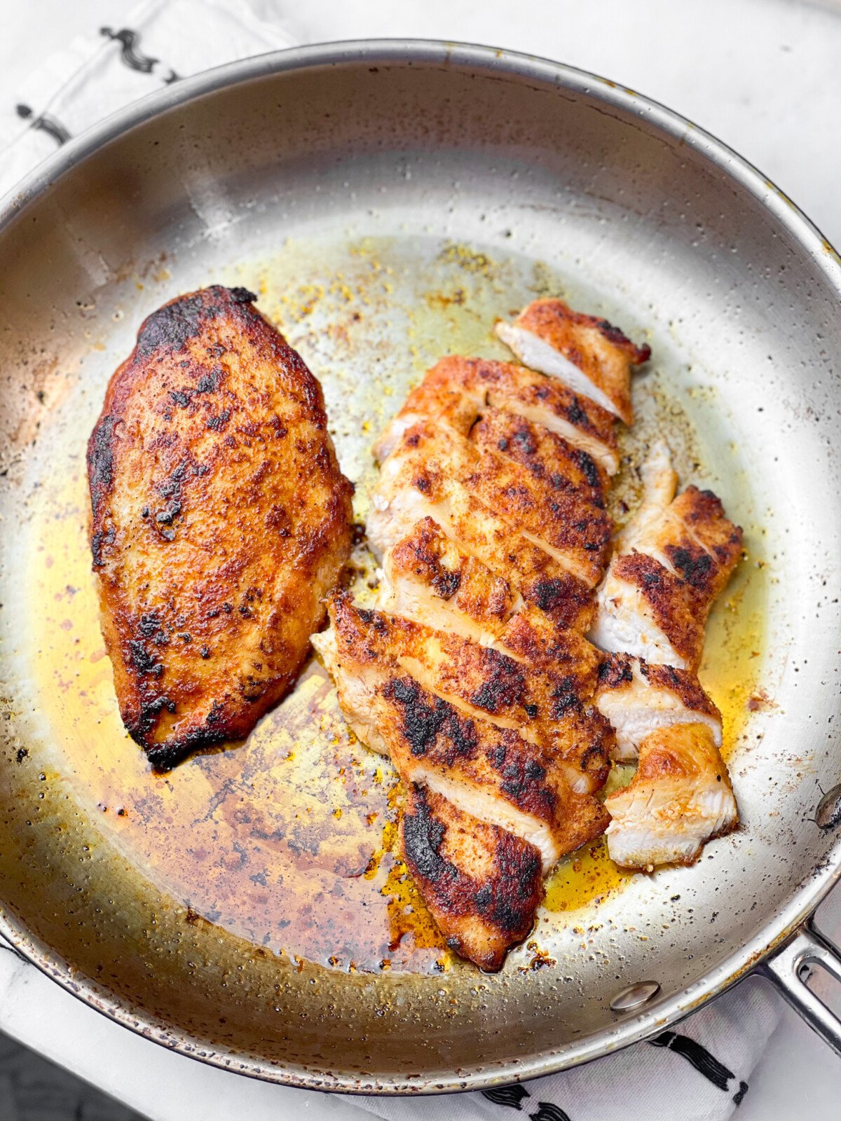 chicken breasts in a stainless steel skillet