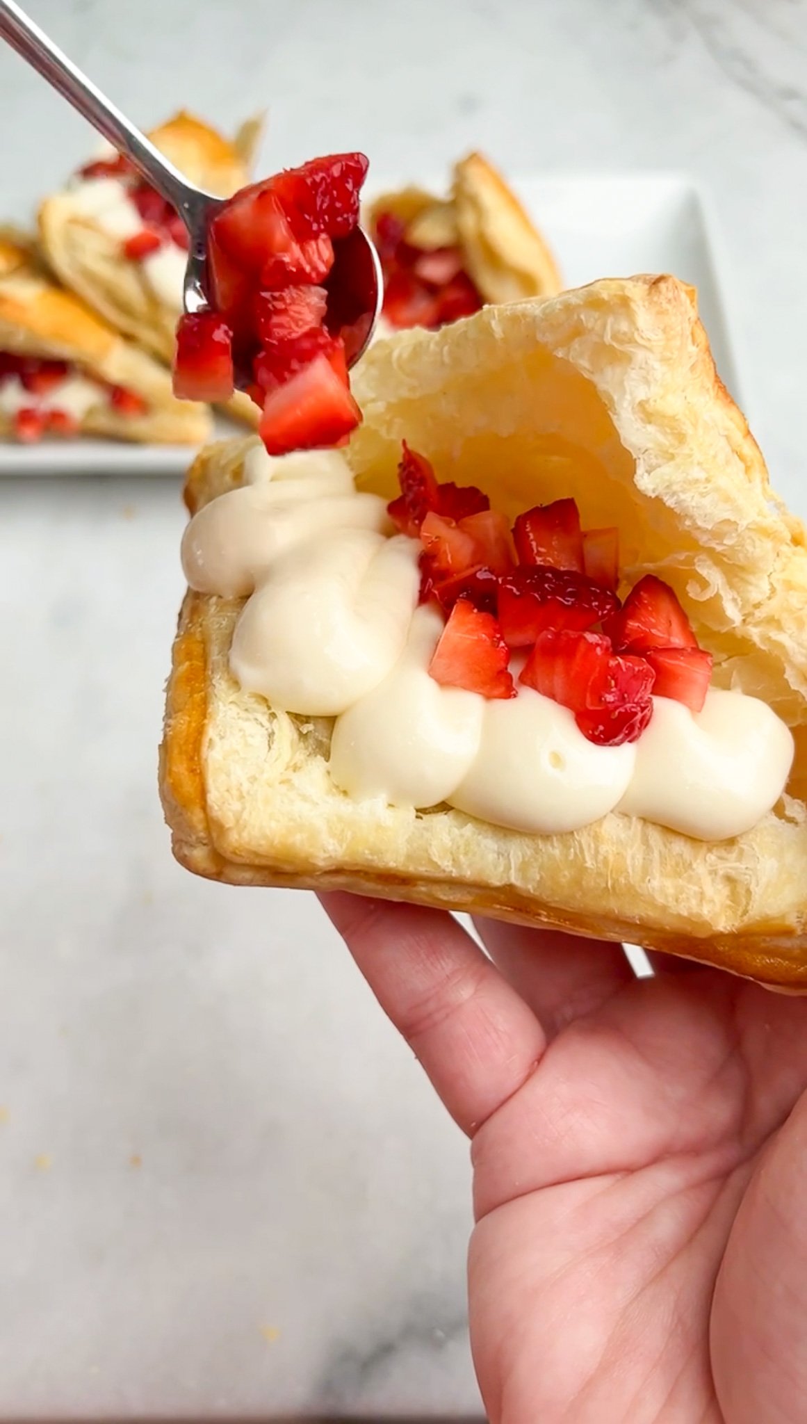 adding strawberries into turnover pastries