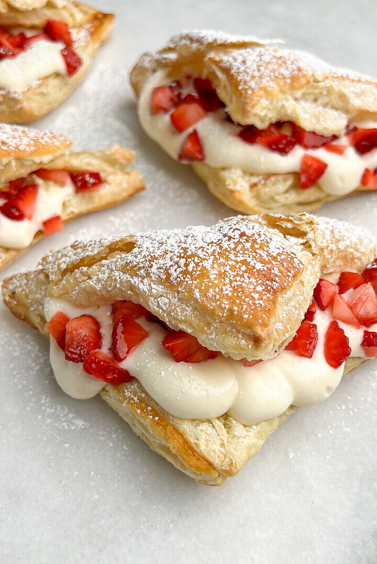 cheesecake and strawberry filled pastries on the counter