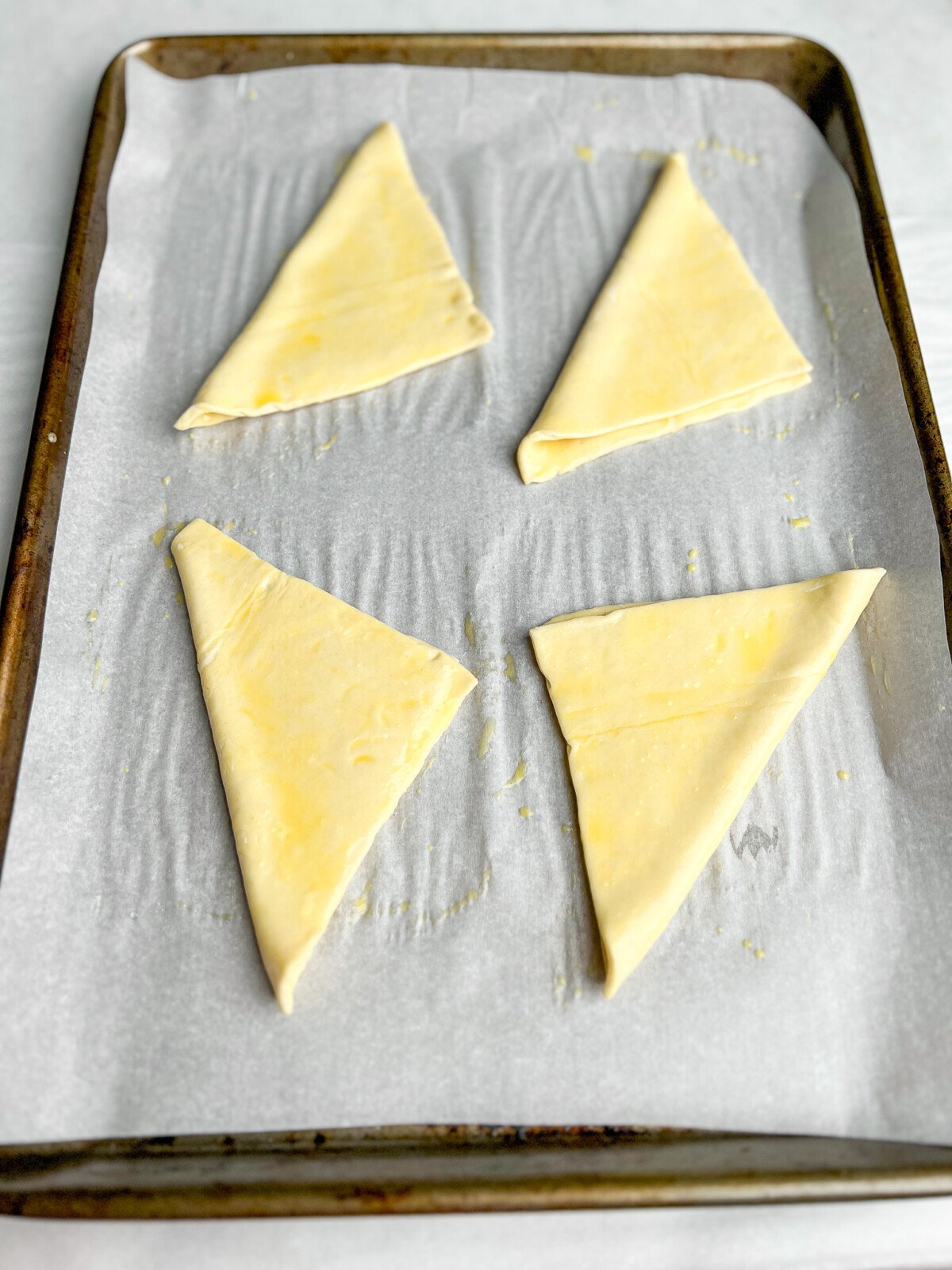 puff pastry folded into triangles on a pan