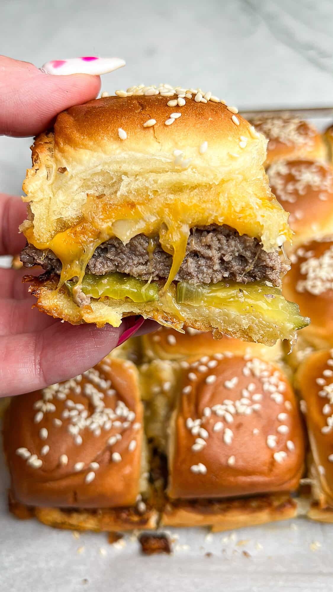 cheeseburger slider being held in hand