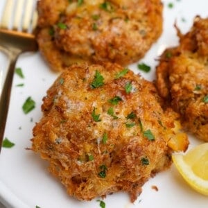 crab cakes on a plate with lemon