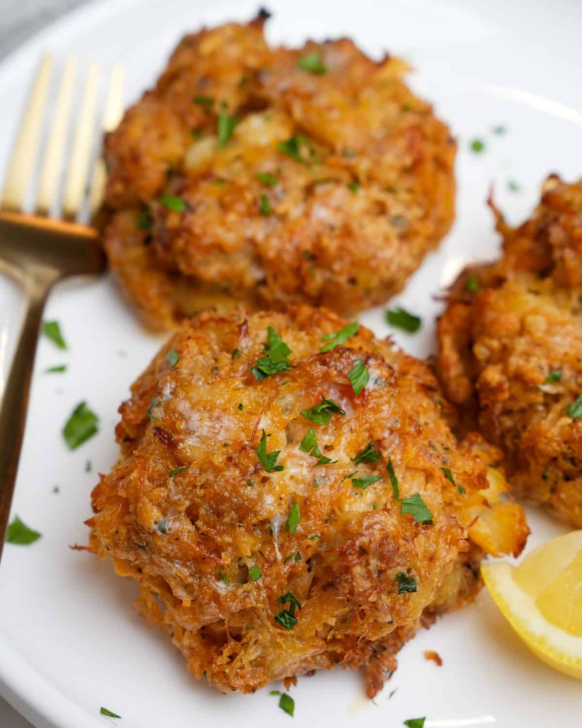 crab cakes on a plate with lemon and parsley