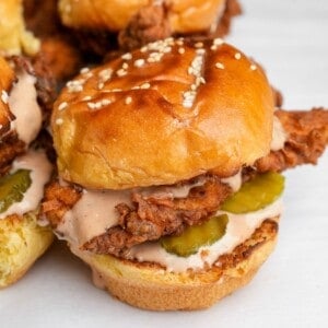 chicken sliders with pickles sitting on a plate
