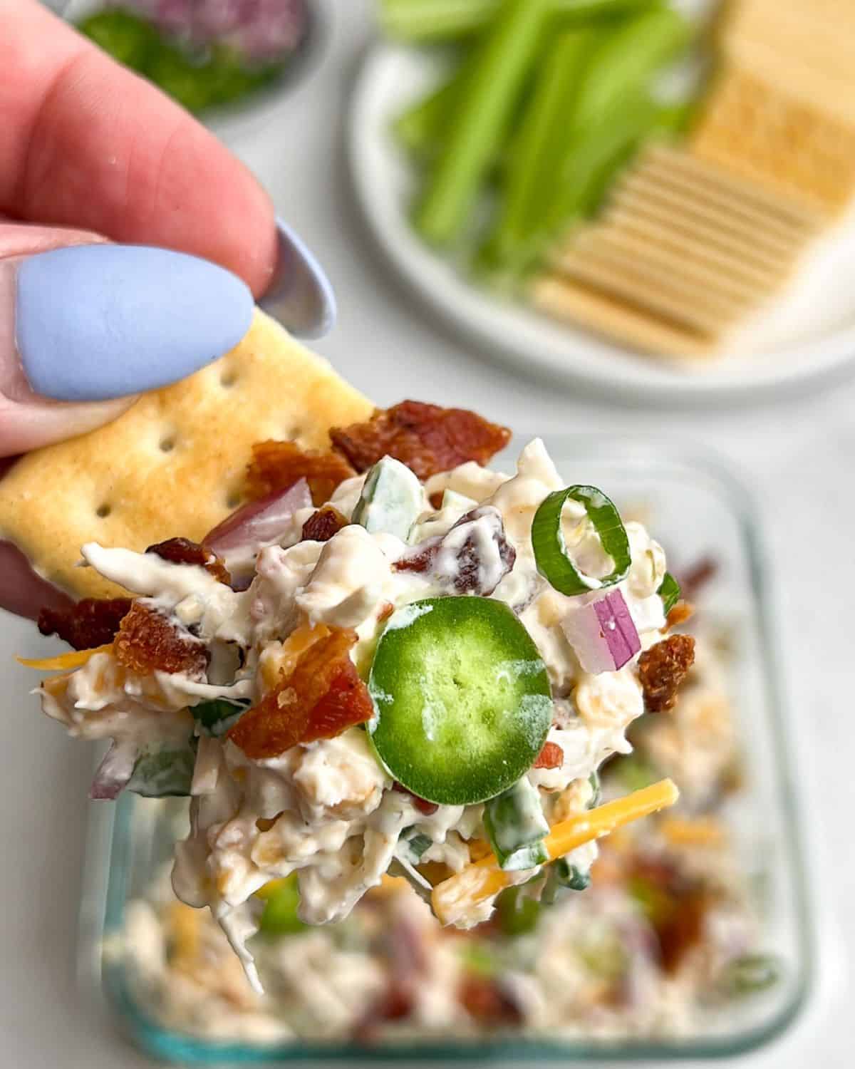 jalapeno popper chicken salad in a bowl and on a cracker