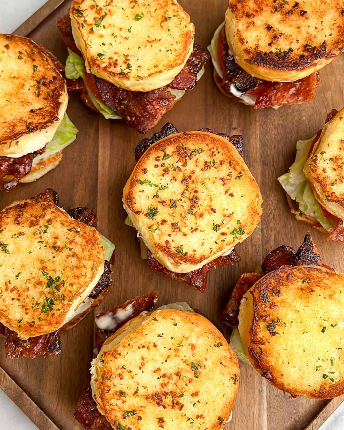 blt sliders on a brown cutting board