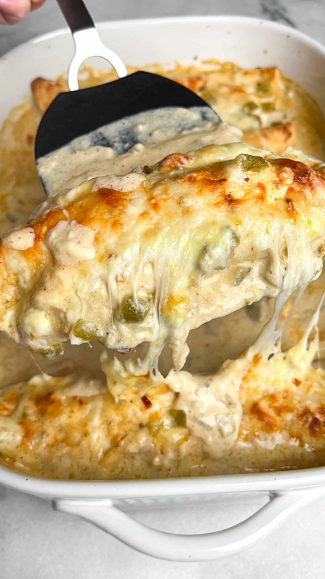 enchiladas baked in a pan and scooped out with a spatula