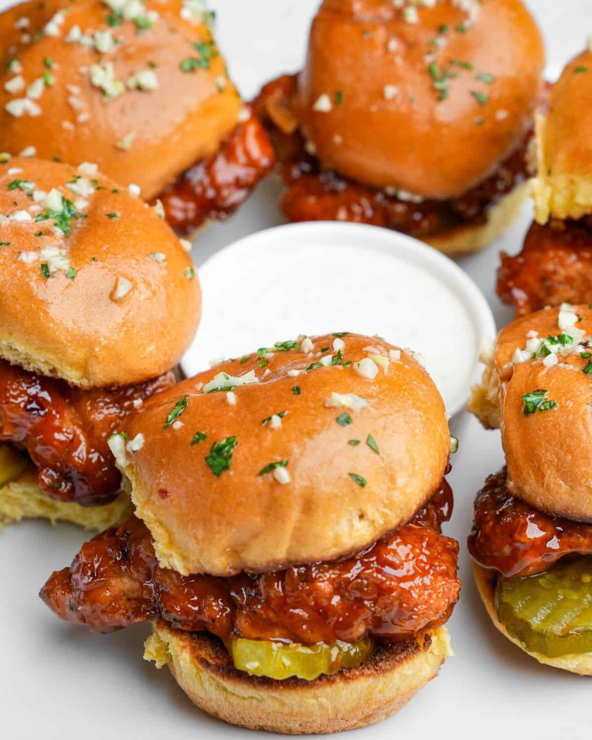 hot honey chicken sliders sitting on a plate with ranch
