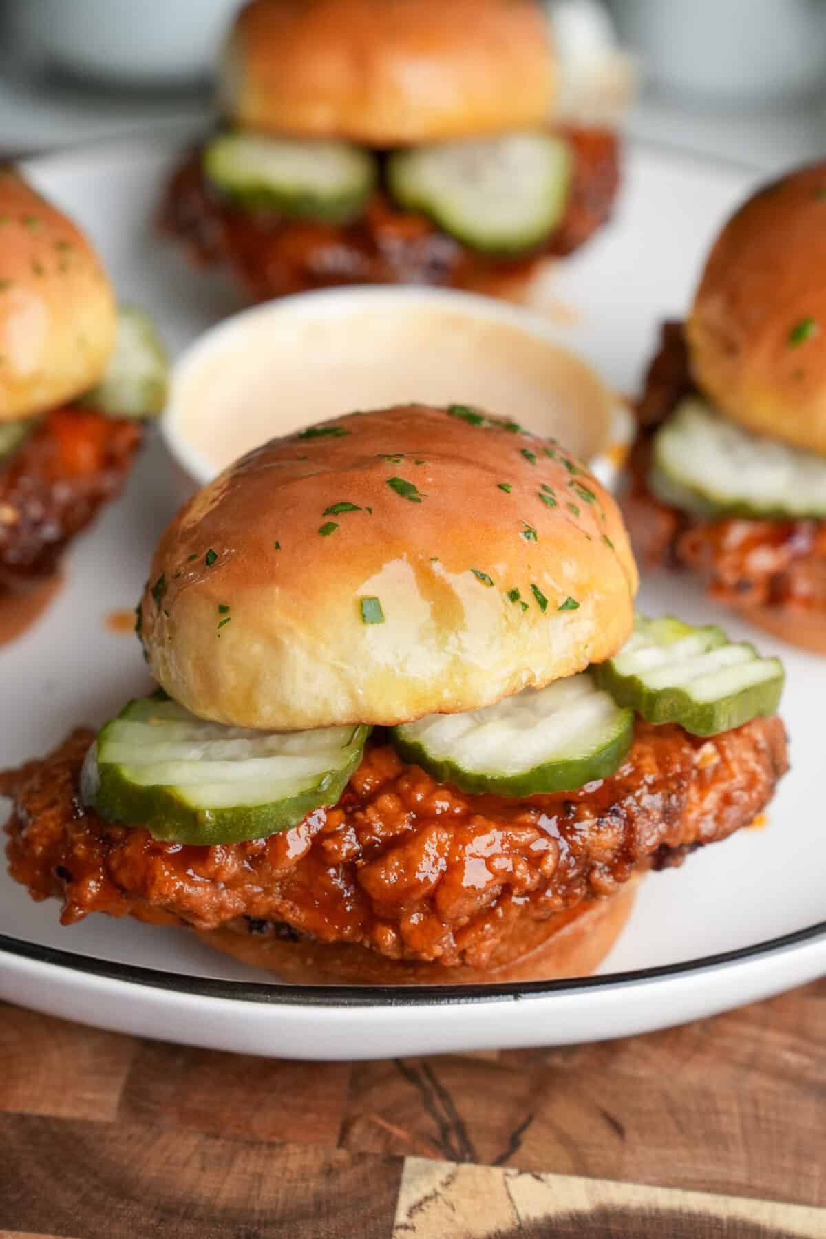 hot honey chicken sliders with pickles on a serving tray