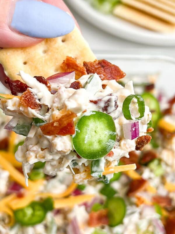 jalapeno popper chicken salad on a cracker being held in hand