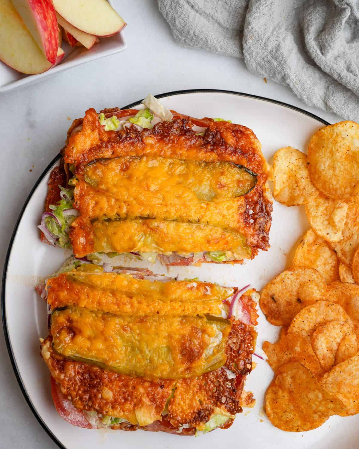 viral pickle sandwich sitting on a plate with chips