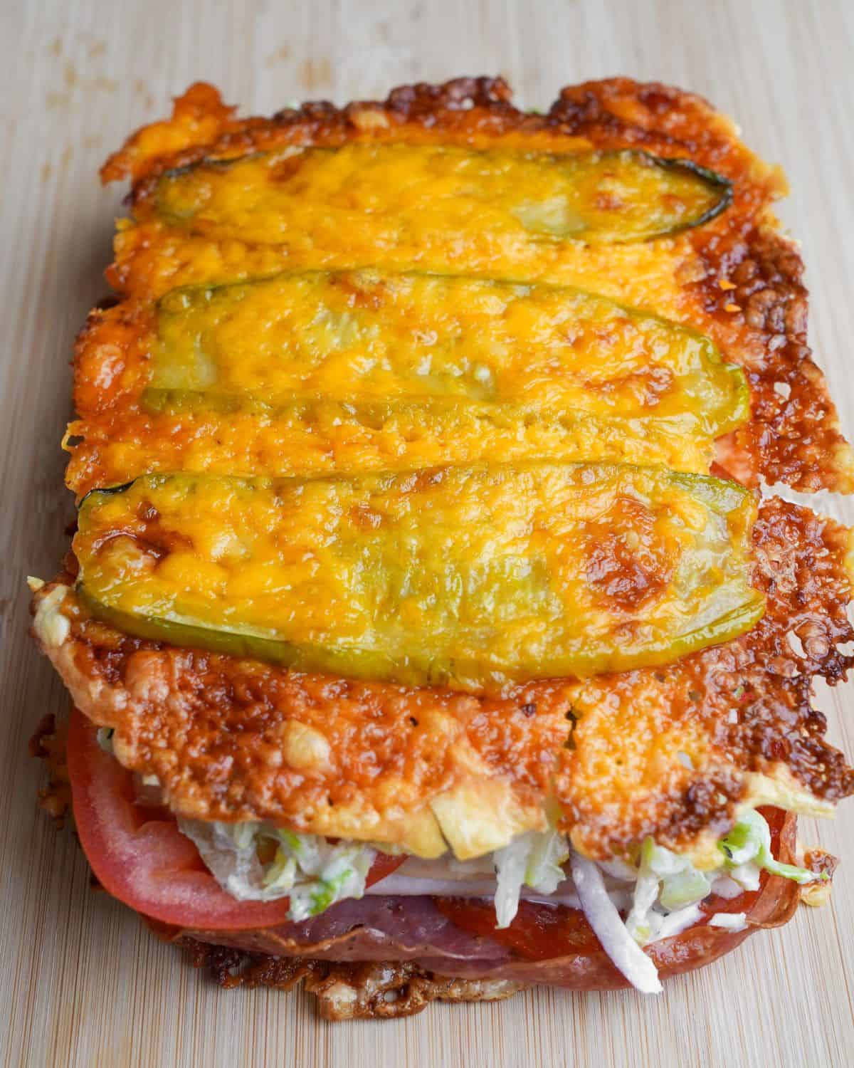 Thinly sliced pickles and shredded cheese are baked together to make a low-carb “bread” in this viral pickle sandwich recipe. A viral pickle sandwich on the counter