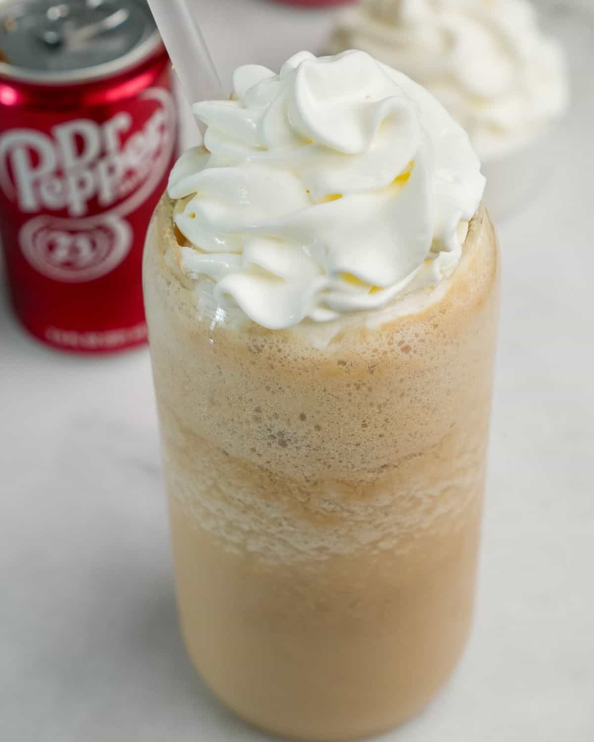 frozen creamy dr pepper in a glass with whipped cream