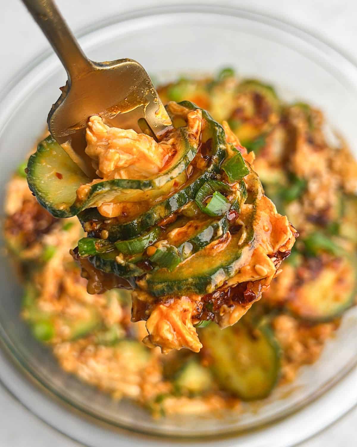 creamy thai cucumber salad with chicken on a fork