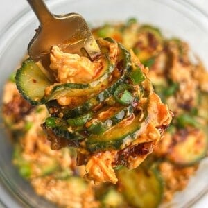 creamy peanut thai cucumber salad with chicken on a fork