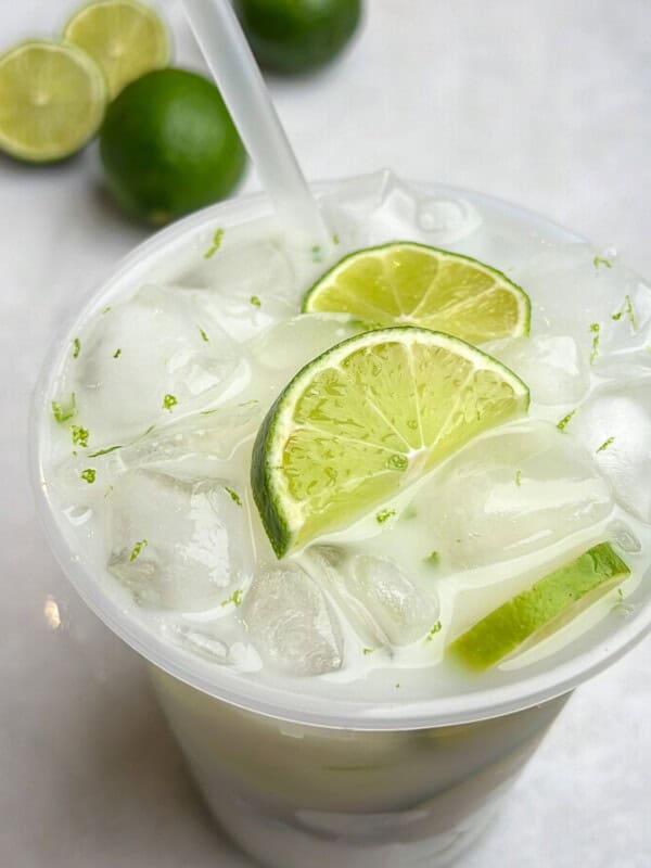 Brazilian limeade in a cup with a straw.