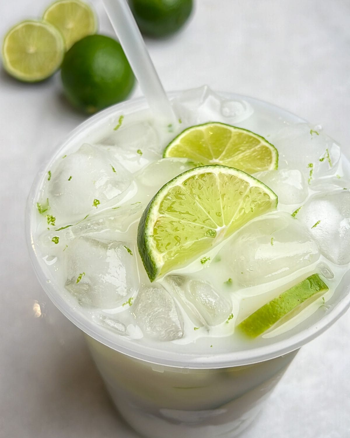 Brazilian limeade in a cup with a straw.