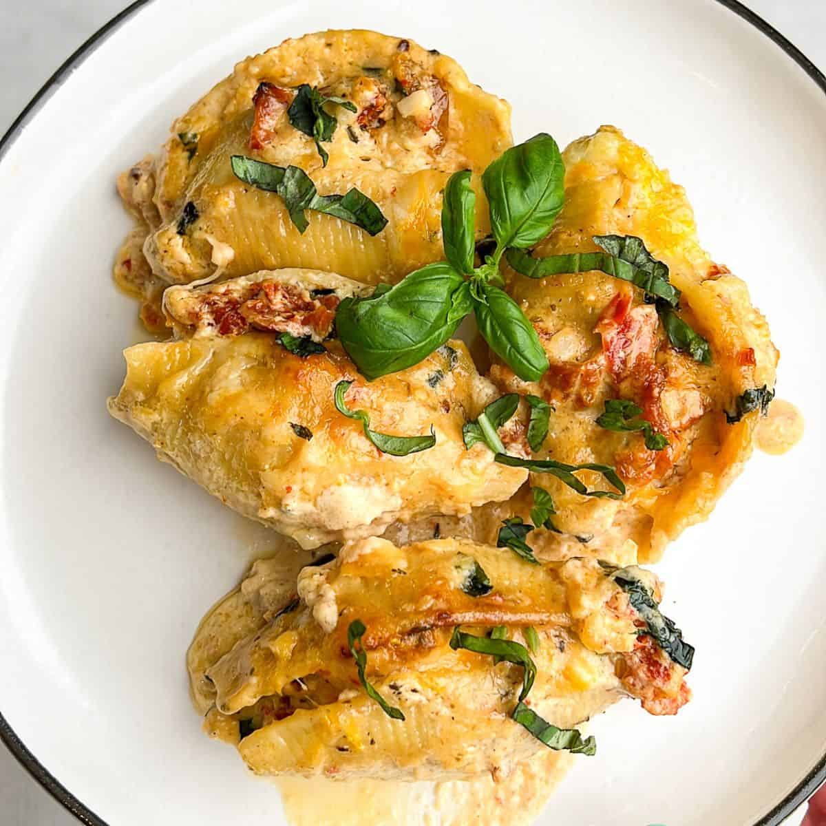 Close-up image of marry me chicken stuffed shells on a plate.