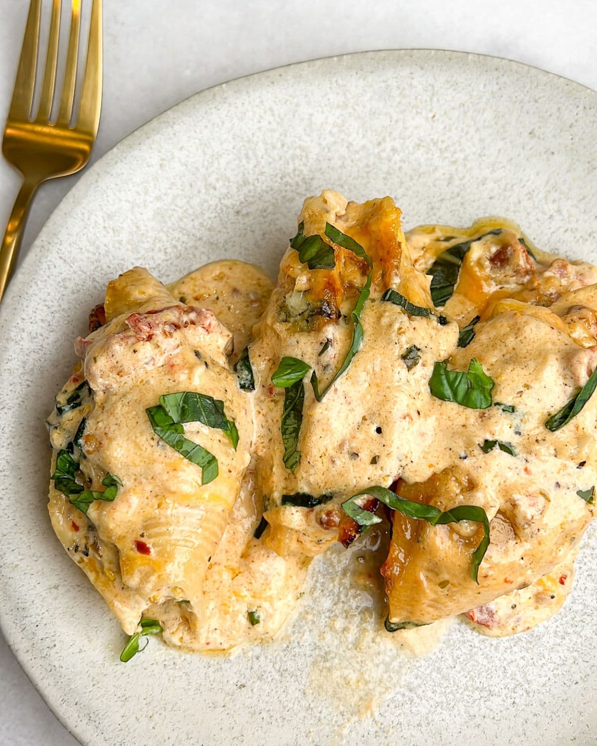 Marry me chicken stuffed shells on a plate.