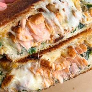 A salmon grilled cheese sandwich, cut in half to reveal the inside.