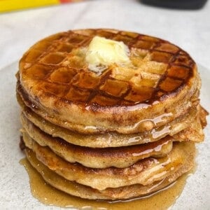 A stack of French toast waffles with butter and syrup.