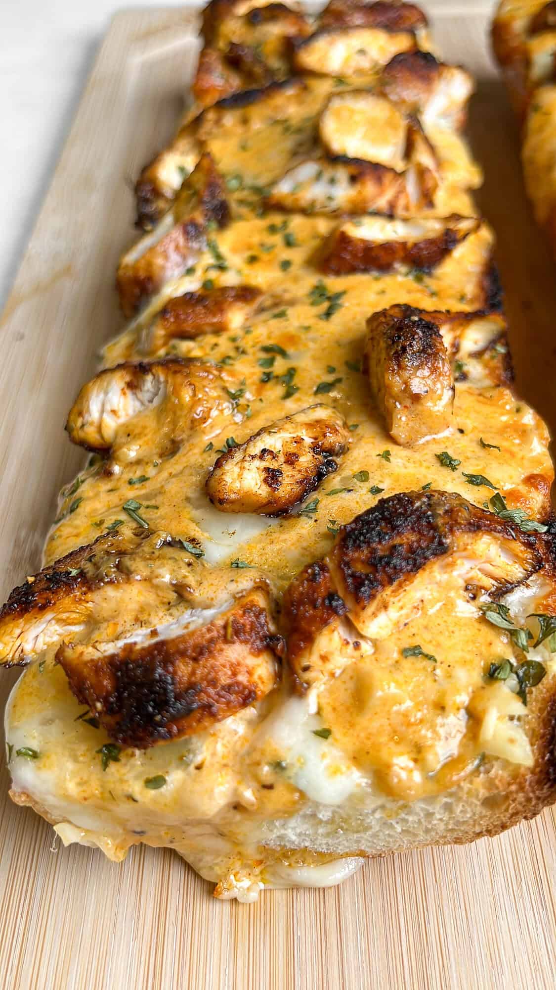 Chicken alfredo garlic bread on a cutting board.
