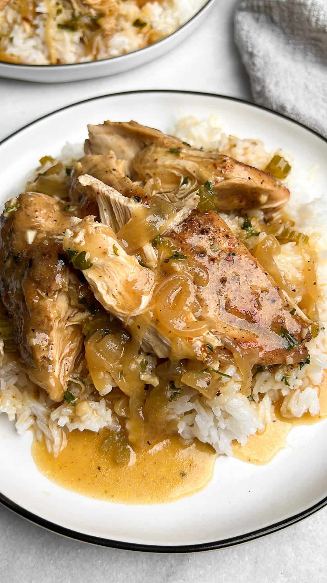 Close-up image of slow cooker smothered chicken served over rice.