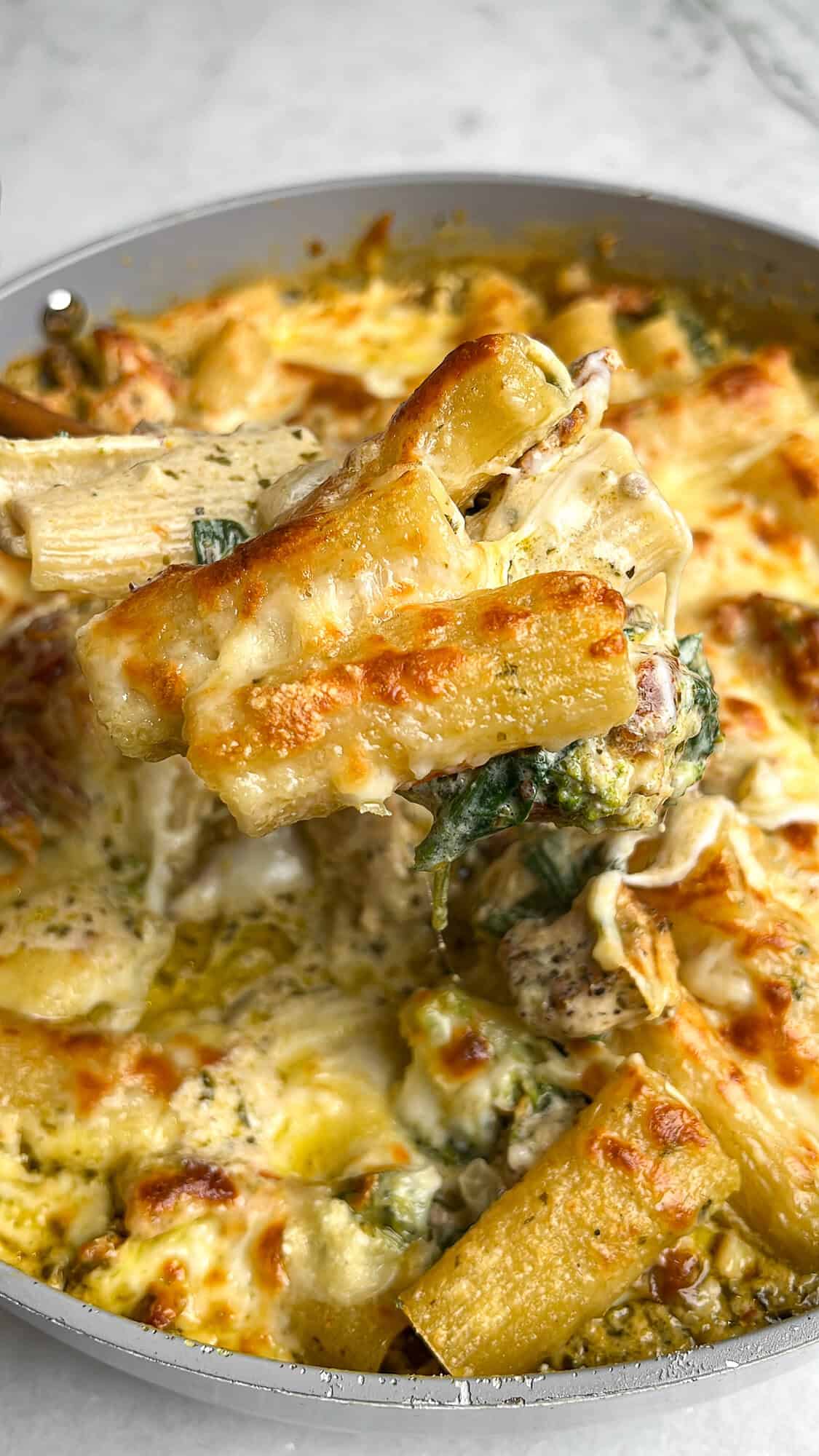 Cheesy, golden brown rigatoni in creamy pesto sauce with chicken and veggies.