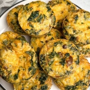 Kale and mushroom egg bites piled on a plate.