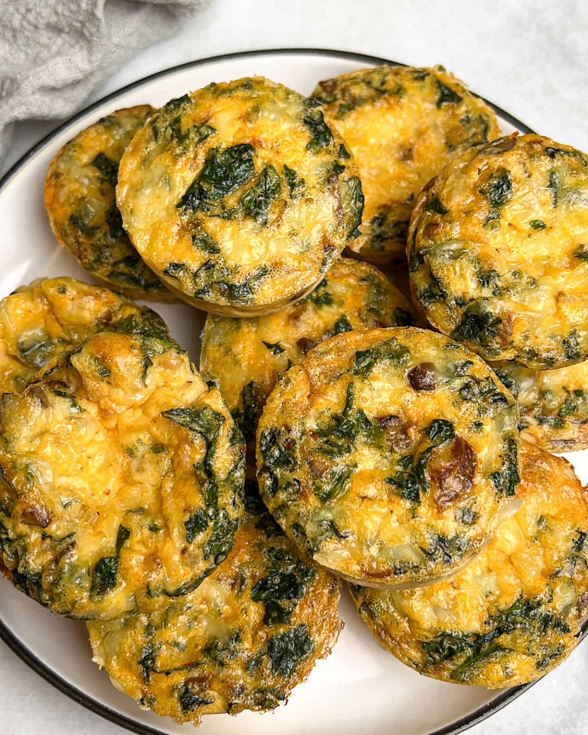 Kale and mushroom egg bites piled on a plate.