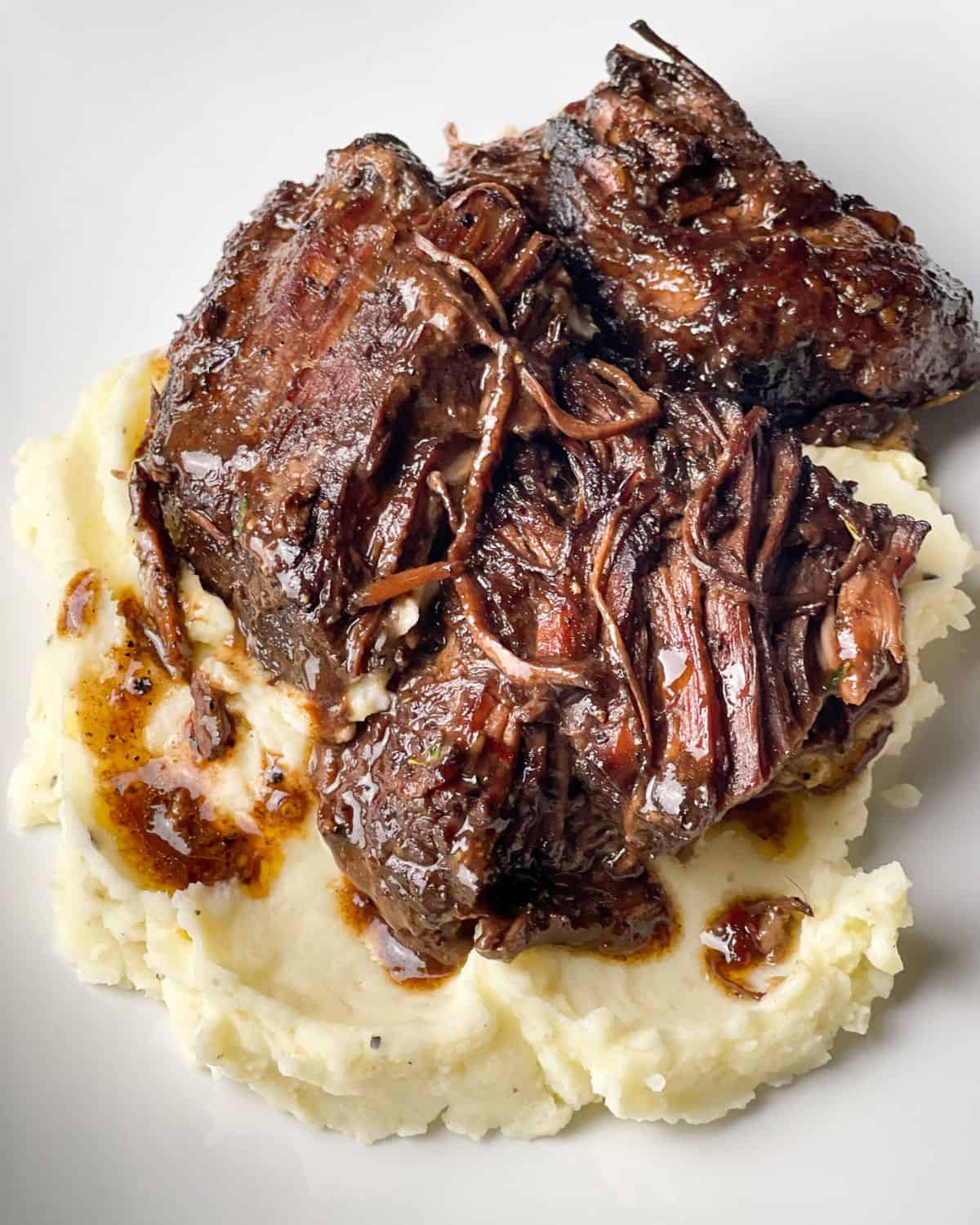 Craving a cozy meal? This red wine pot roast is it! With tender meat and rich flavors, it’s an indulgent dish made for chilly nights. Red wine pot roast served over mashed potatoes.