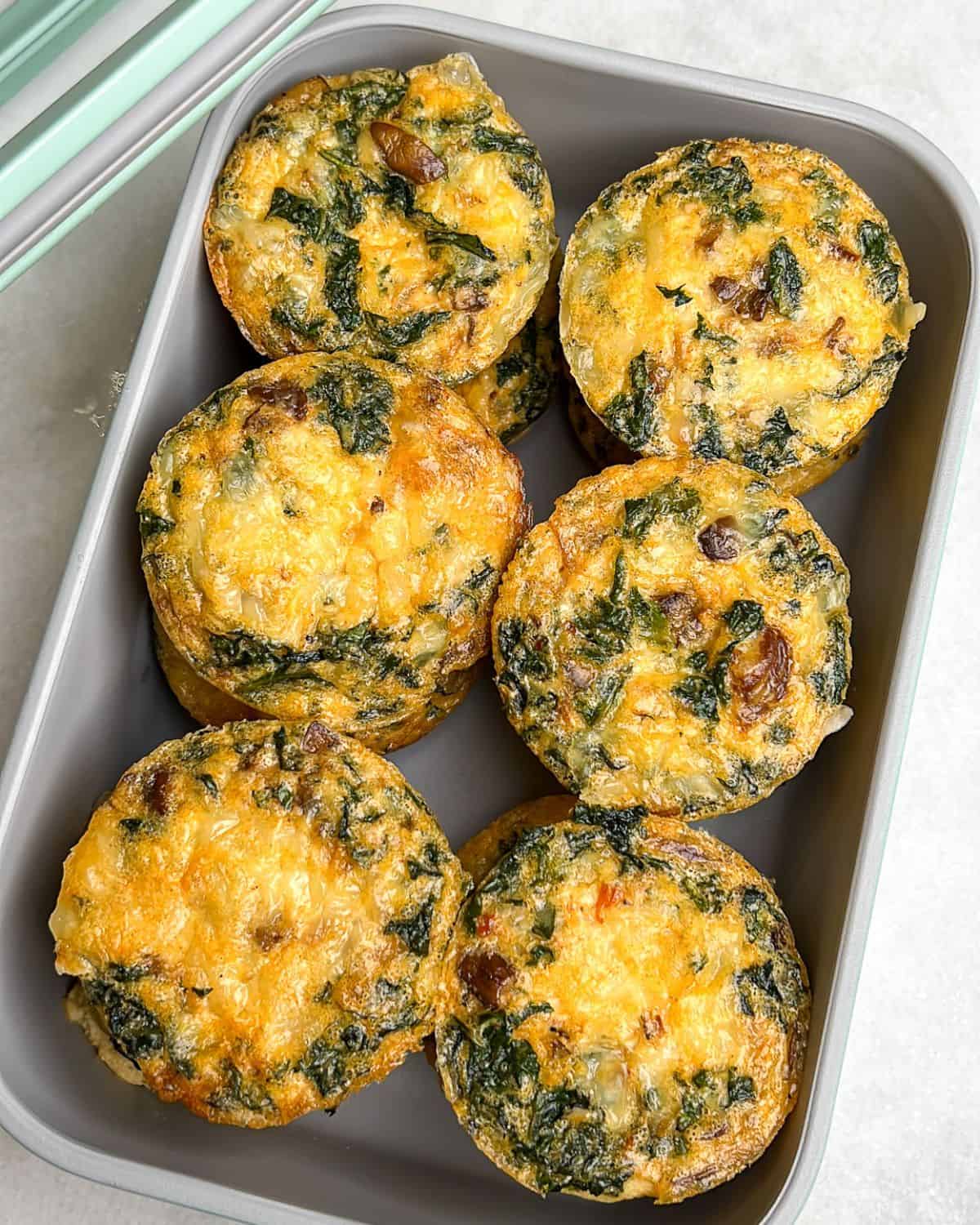 Kale and mushroom egg bites in a storage container.