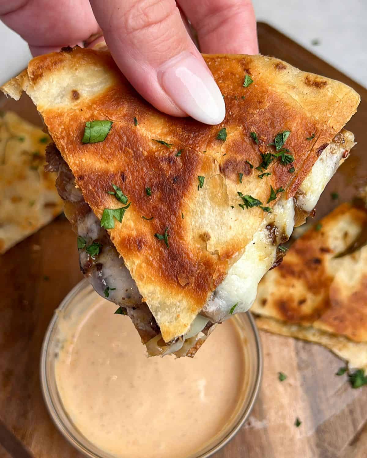 steak quesadillas held in hand