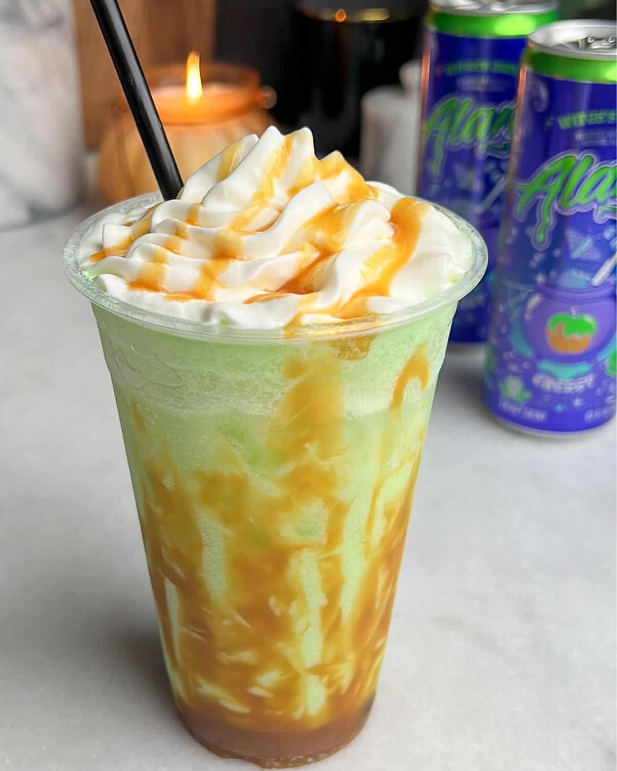 green apple drink with caramel sauce drizzled on the side and whipped cream on top
