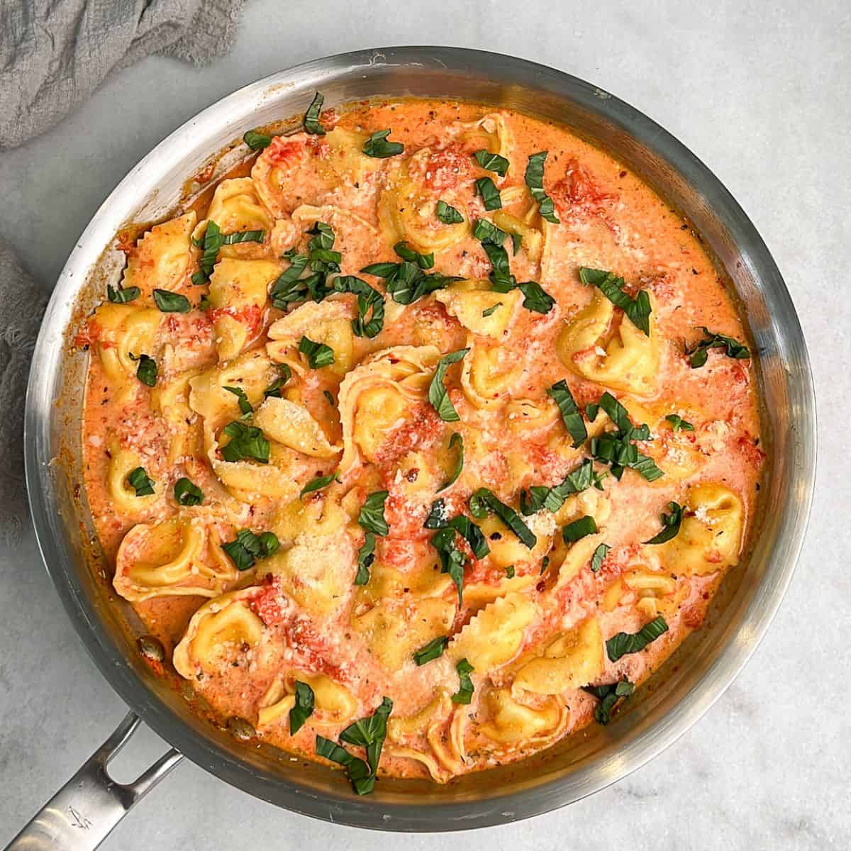 a pan filled with creamy tomato tortellini