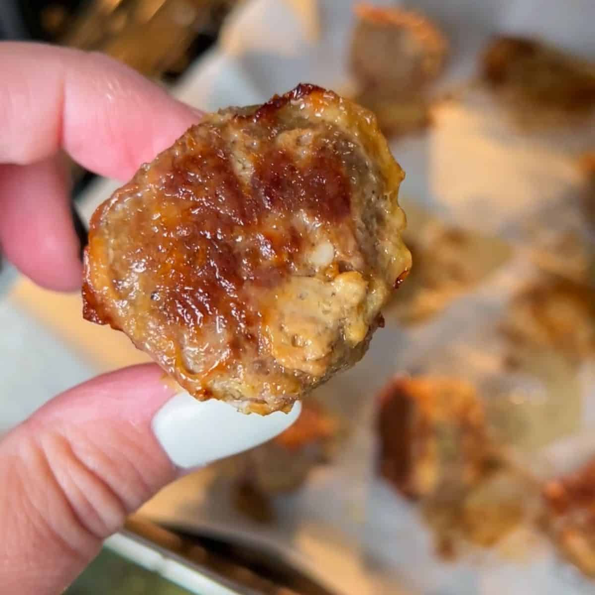 up close image of meatballs baking on a baking sheet.