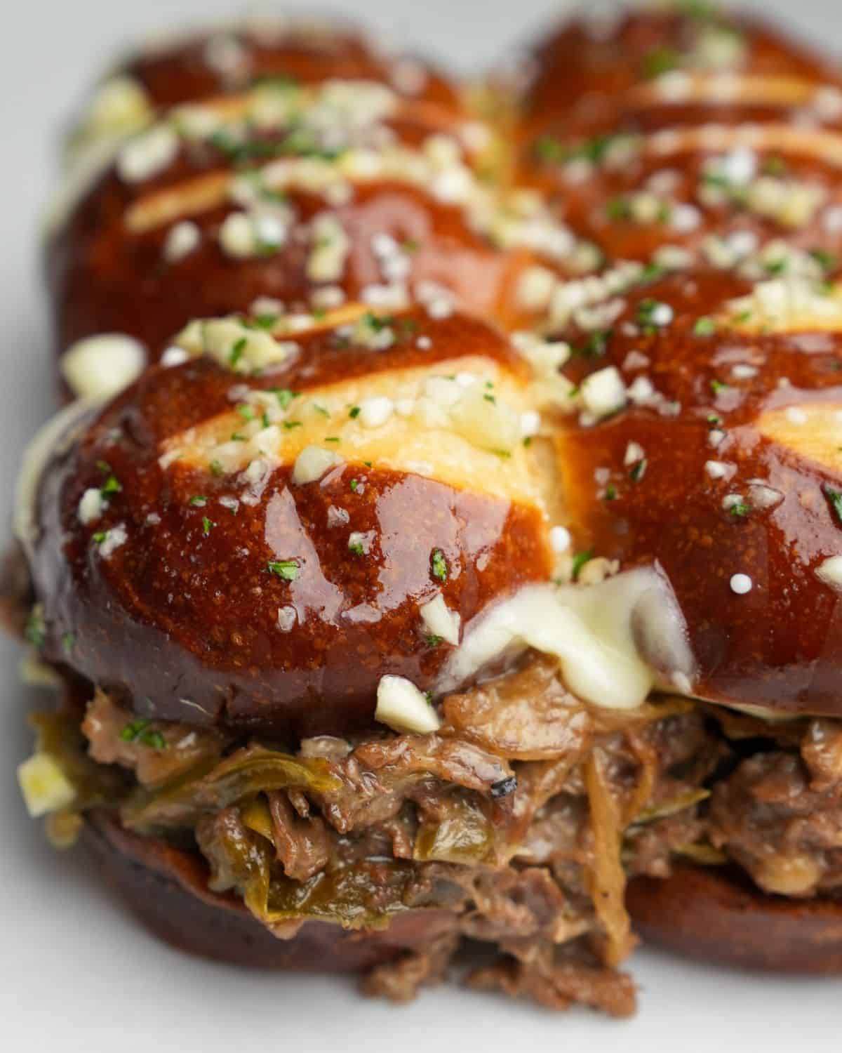 Close-up image of a Philly cheesesteak slider with garlic butter.