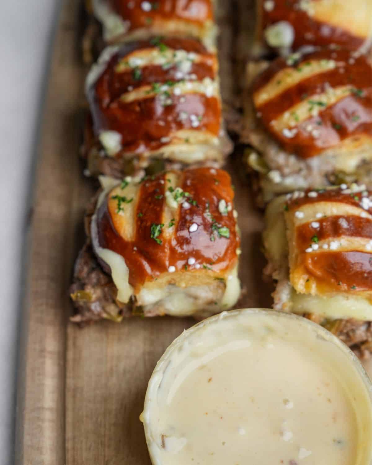 Close-up image of a Philly cheesesteak slider with cheez whiz and garlic butter.