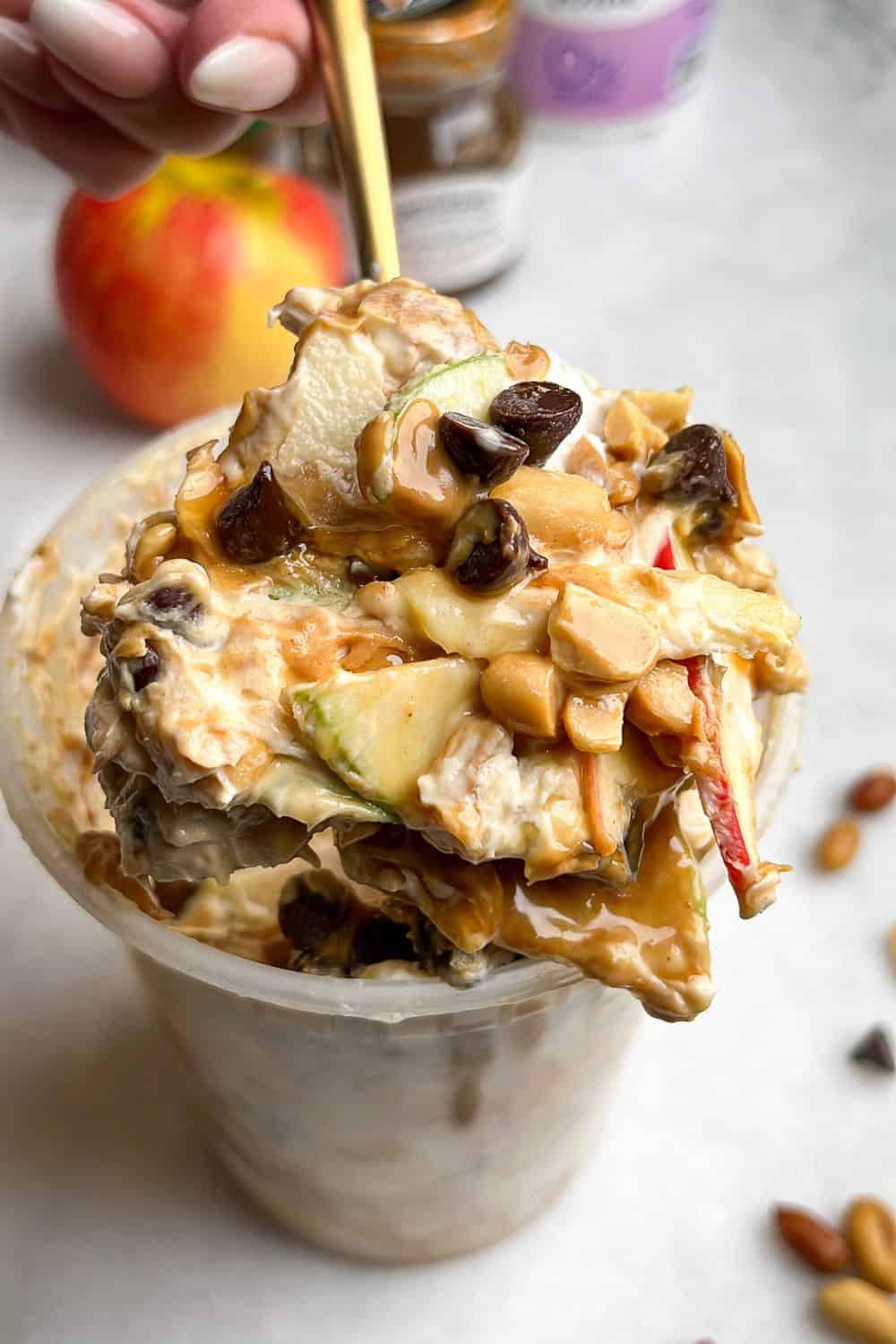 snickers salad in a container with a spoon